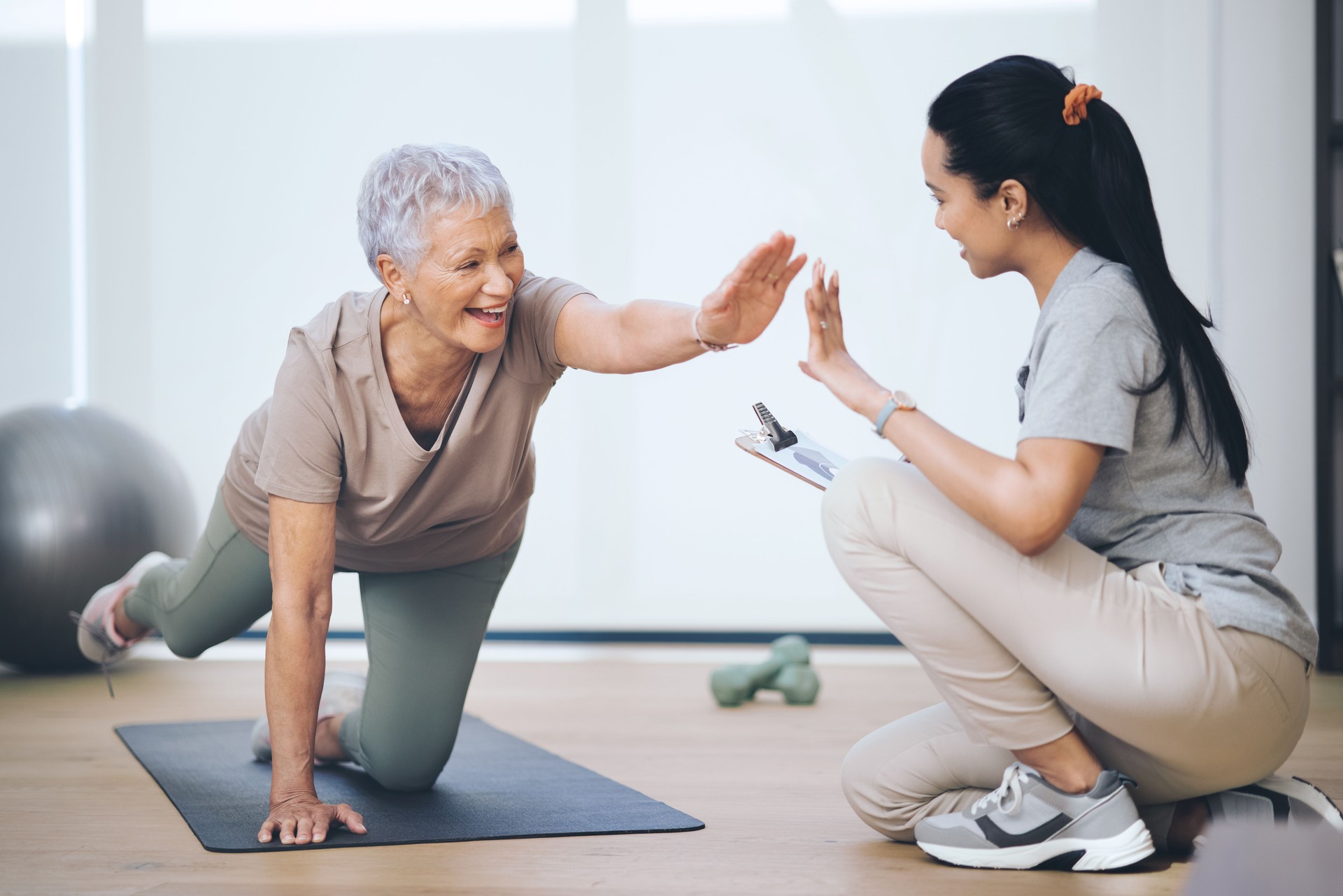 Shot of an older woman doing light floor exercises during a session with a physiotherapist